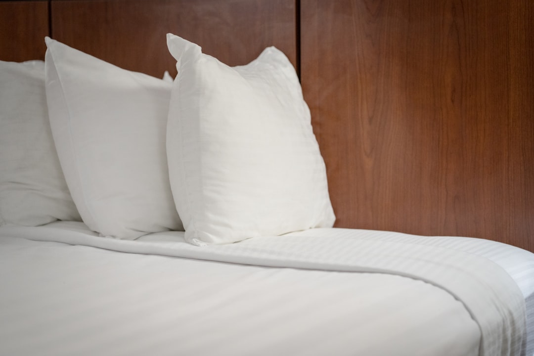 services-01 a-group-of-white-pillows-on-a-bed-w1x69vgn4k8