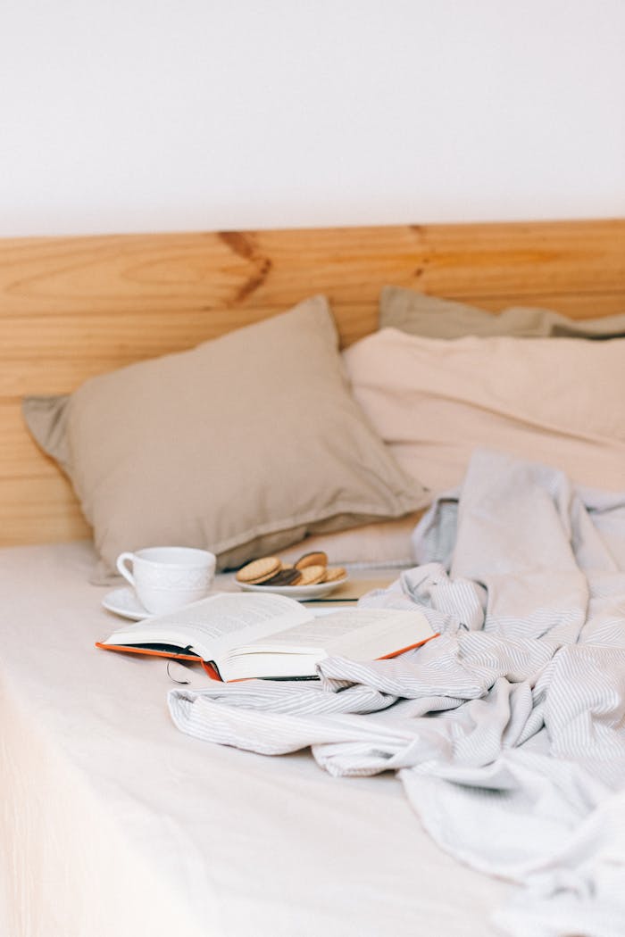 services-02 Relaxing scene of a cozy bed with book, coffee, and cookies for a perfect reading time.